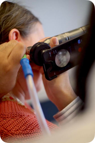 A person using a tool to check the ear